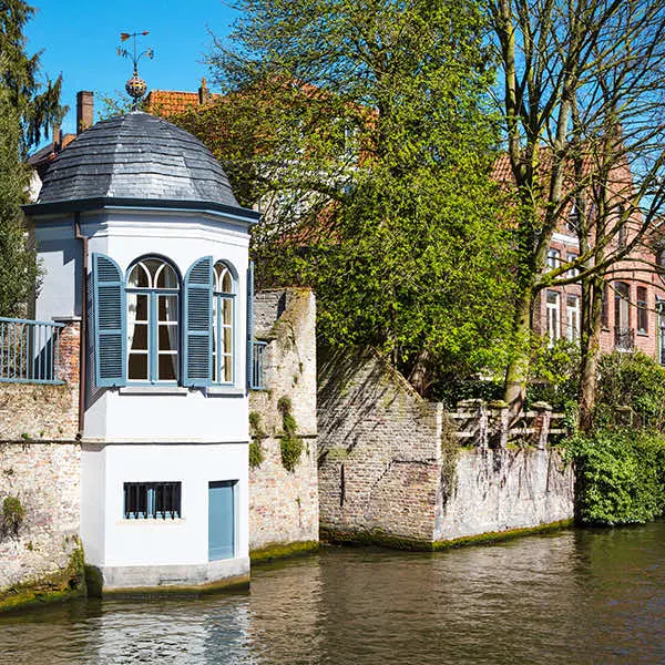 Wit torentje met leien dak aan het water in Brugge