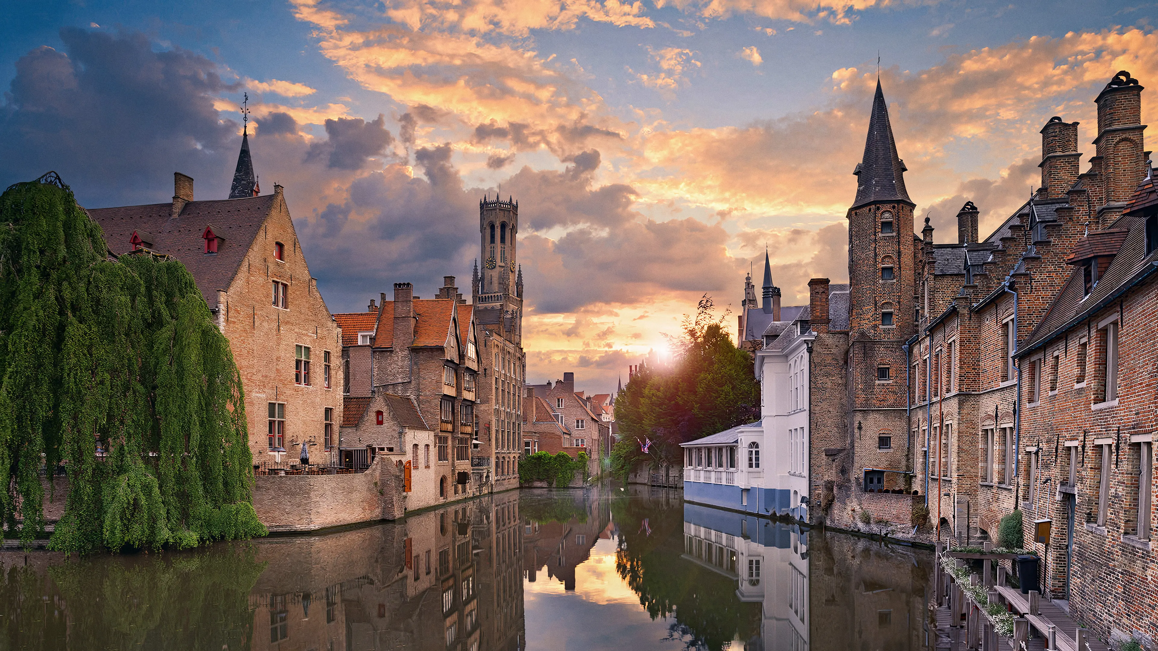 De Rozenhoedkaai in Brugge bij zonsondergang, met het Belfort op de achtergrond