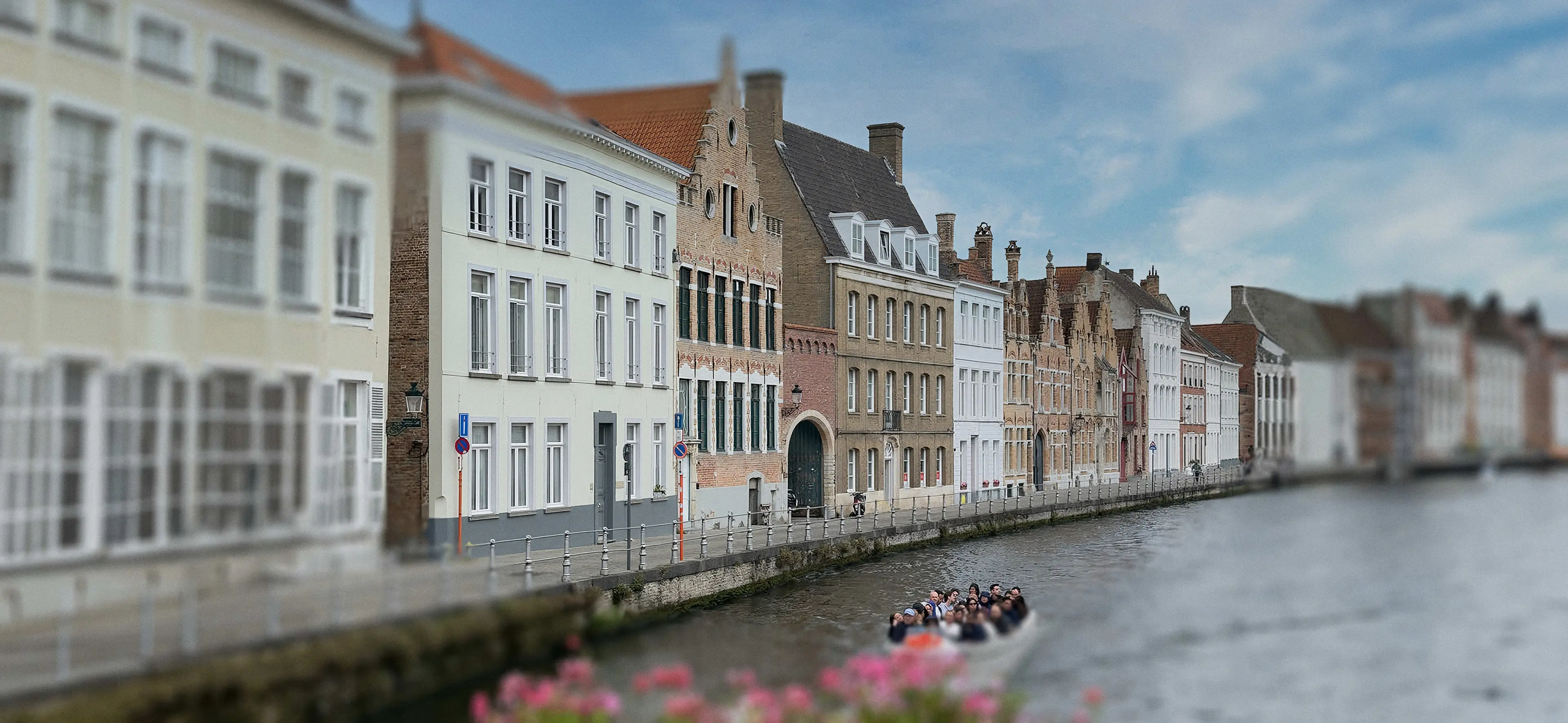 Gevels langs de Sint-Annarei in Brugge, waar B&B Quay17 ligt, met een rondvaartboot op de reie