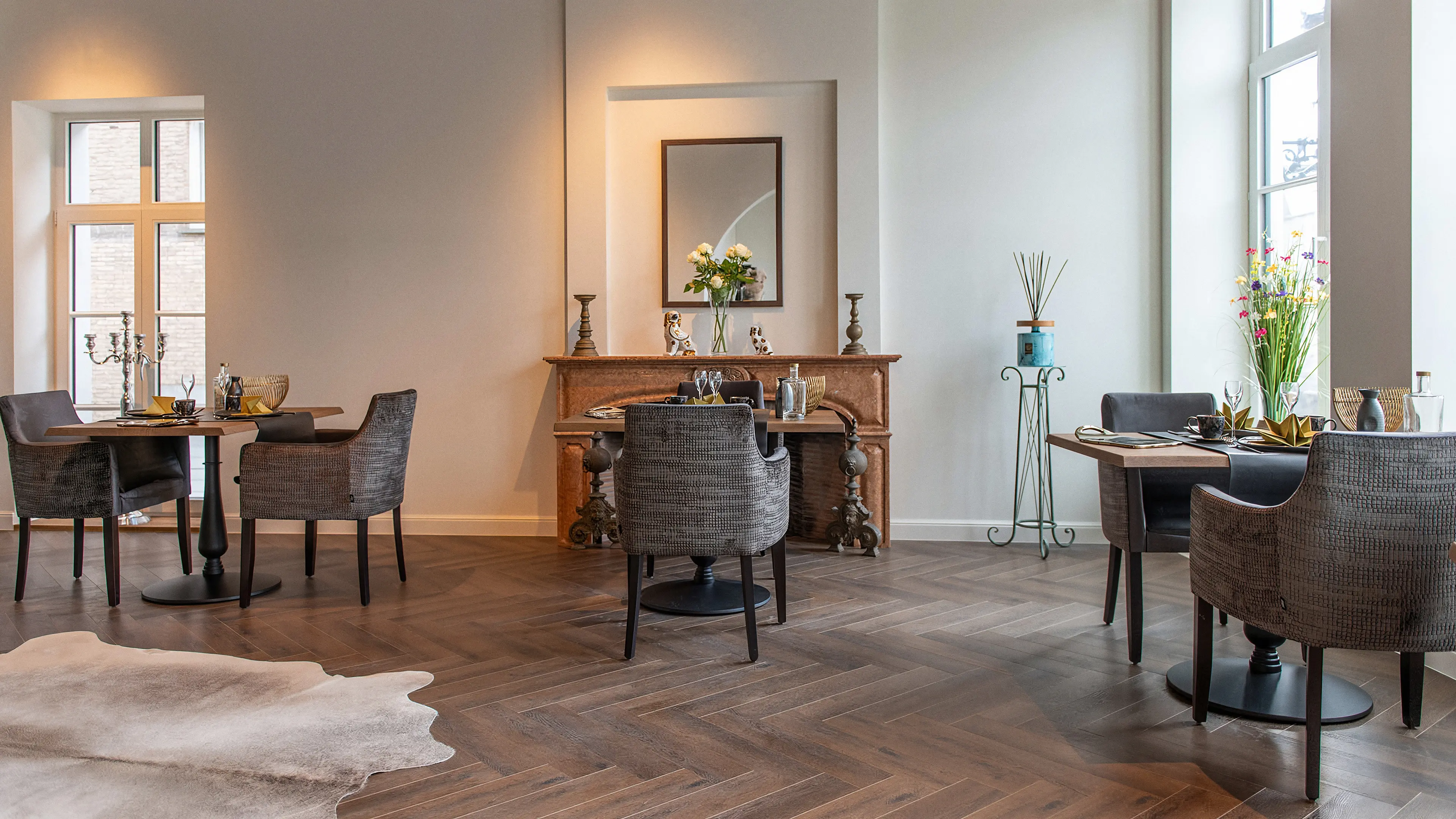 Lichte ontbijtzaal met gedekte tafels, rieten stoelen en visgraatparket