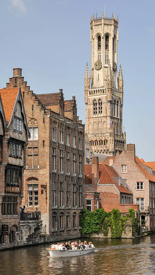 Het Belfort van Brugge boven de Rozenhoedkaai, met een rondvaartboot op de rei