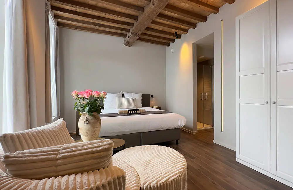 Deluxe kamer met stadszicht (25 m²): fauteuils en bed onder het balkenplafond