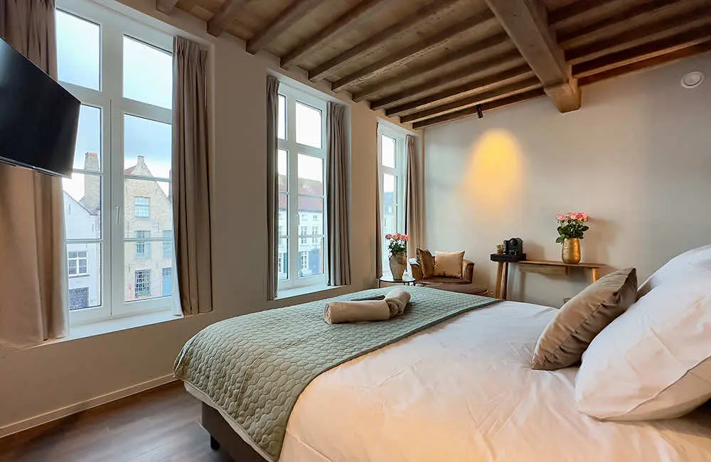 Deluxe kamer met waterzicht (26 m²): tweepersoonsbed bij de hoge ramen onder het balkenplafond