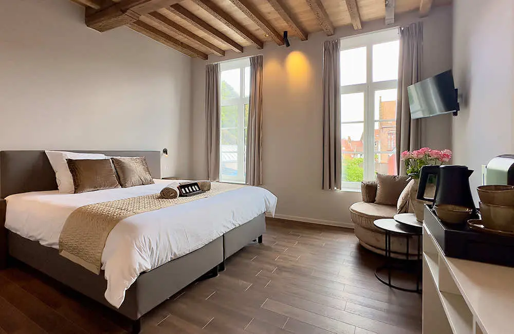 Deluxe kamer met stadszicht (22 m²): tweepersoonsbed en fauteuil onder het balkenplafond